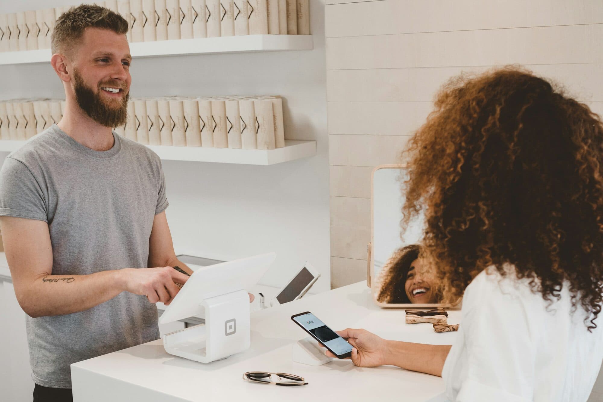 A small-business owner serving a customer at the counter.