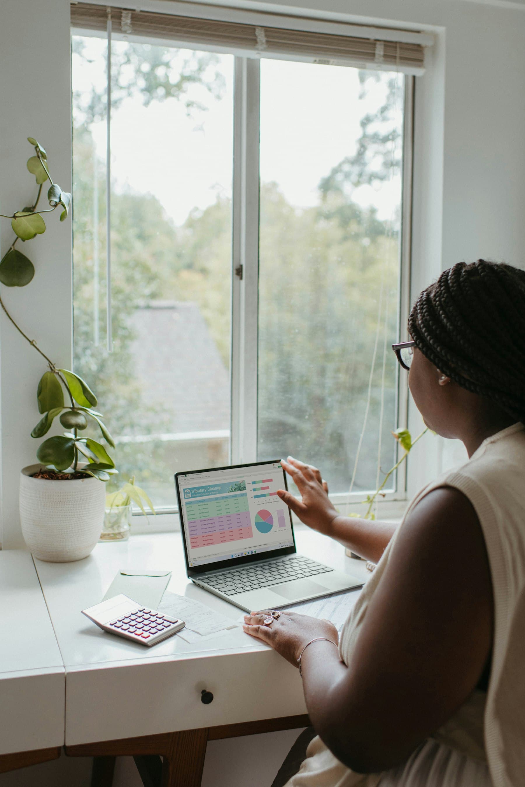 A business owner going through her figures at a desk by the window.